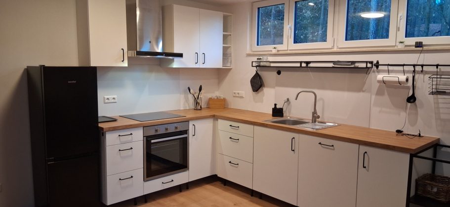 Küchenbereich mit Herd Ceranfeld Spülmaschine und Kühl-Gefrierschrank